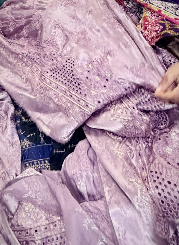 Hands finishing a lilac jacquard piece with cutwork
