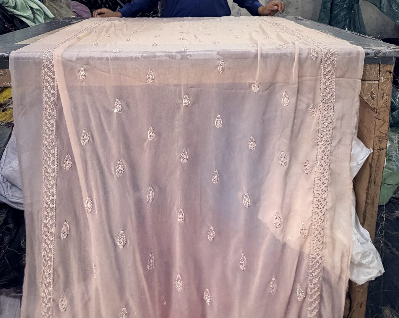Embroidered blush dupatta laid on the finishing frame