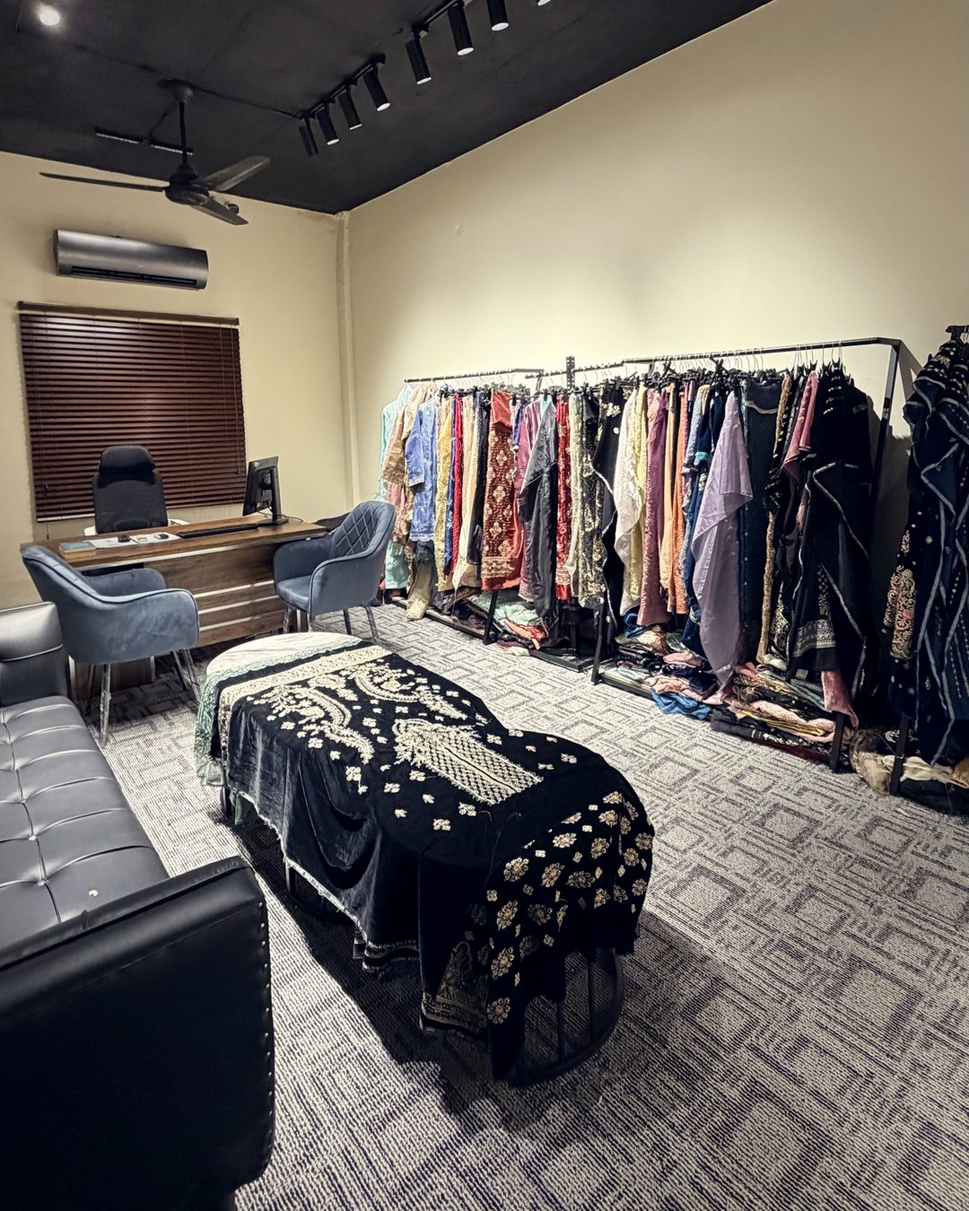 Subhan Tex sampling room with track lighting, sample racks, seating and velvet display table