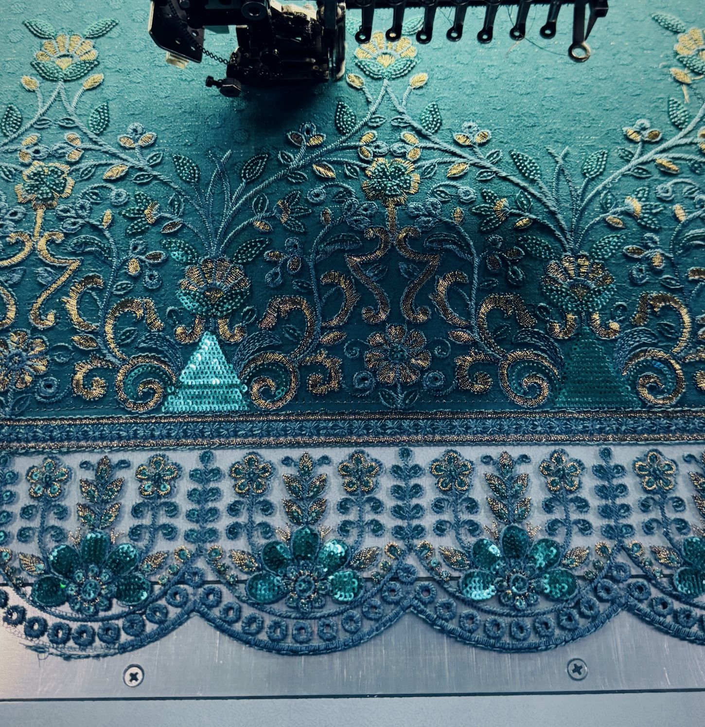 Teal net border with sequin and thread embroidery under the machine