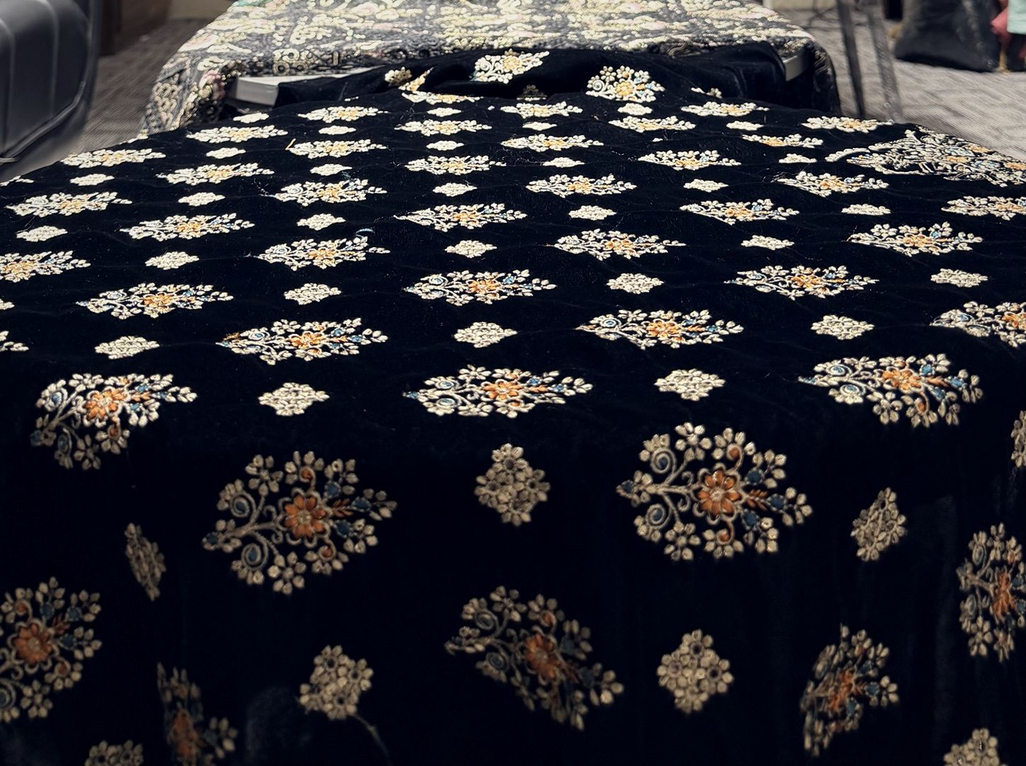 Close-up of black velvet with gold and copper floral embroidery